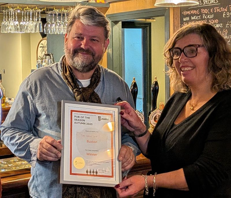 The owners of the New Inn Buxton showing their Pub of the Season Certificate